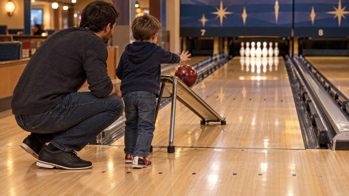 Child pushing a bowling ball down a ramp while a parent crouches beside them on the approach