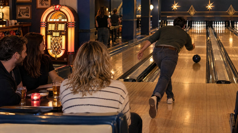Bowlinghal i retrostil med en lysende jukebox, gæster ved et bord og en bowler i afleveringen