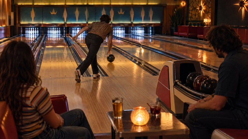 Spiller slipper kuglen i en bowlinghal i retrostil, gæster ser på fra deres pladser