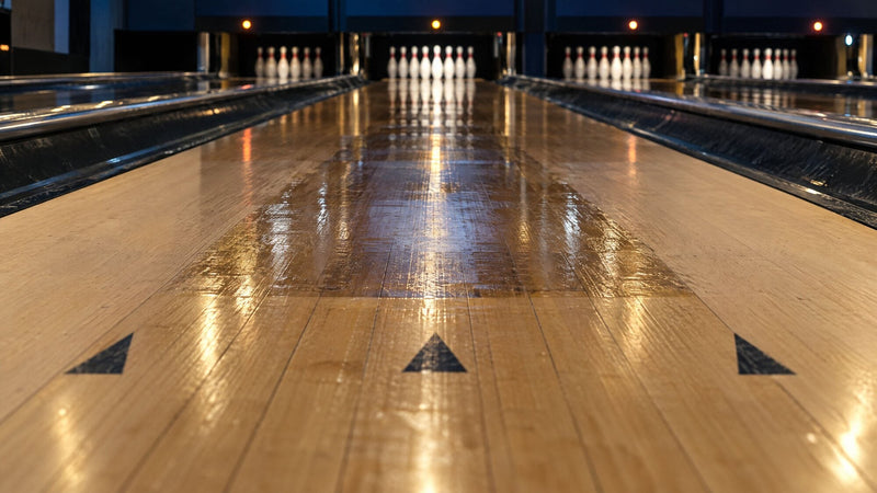 Olaj csillog egy fa bowlingpálya középső deszkáin, elöl a célzó nyilakkal